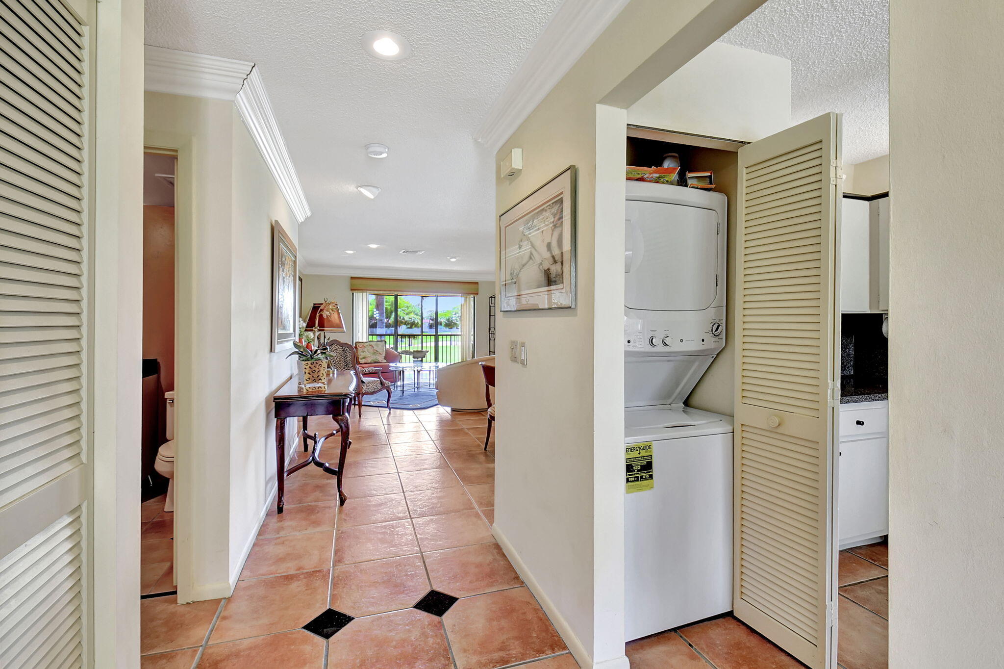 3 Stratford Drive, Unit H Boynton Beach, FL 33436 - Photo 5 of 81 a hallway with dining area and chandelier
