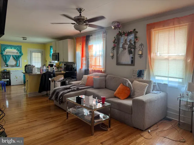 a living room with furniture ceiling fan and a window