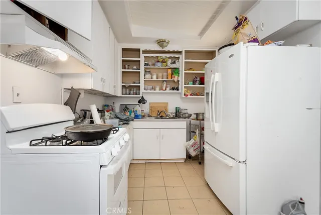 a kitchen with a refrigerator and white cabinets