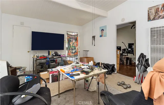 a work room with furniture a flat screen tv and a table