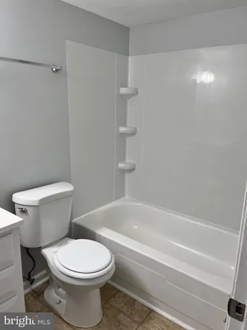 a white toilet sitting next to a bath tub