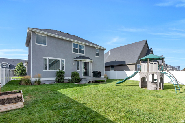 2194 Autumn Drive Mapleton, UT 84664 - Photo 26 of 41 Expansive backyard featuring a manicured lawn, white vinyl fencing, and raised garden beds
