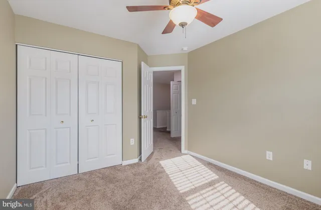 wooden floor in an empty room with a chandelier fan