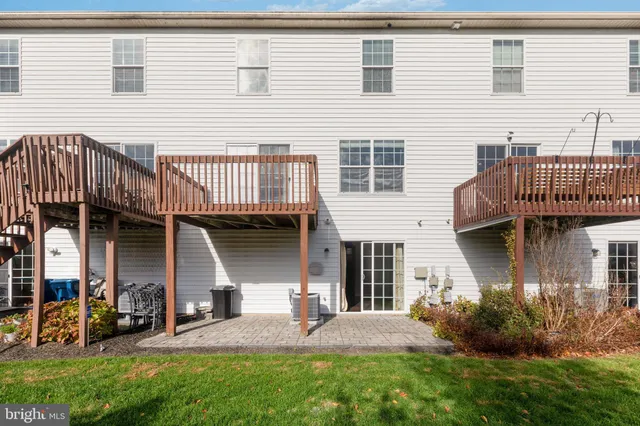 a view of a house with brick walls and a yard with plants