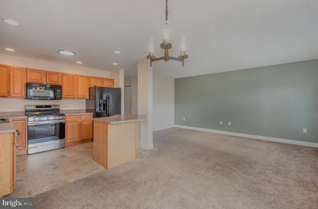 a kitchen with kitchen island white cabinets and stainless steel appliances