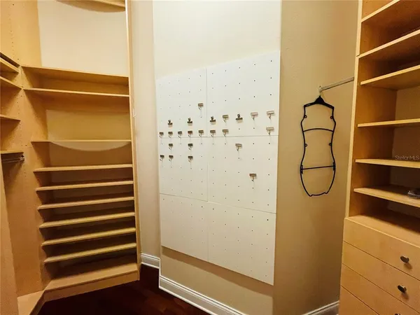 a view of walk in closet with empty racks