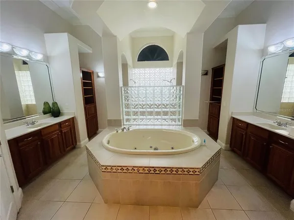 a spacious bathroom with a tub sink and mirror