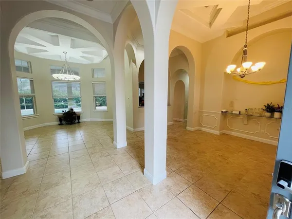 a view of a hallway with chandelier and glass door
