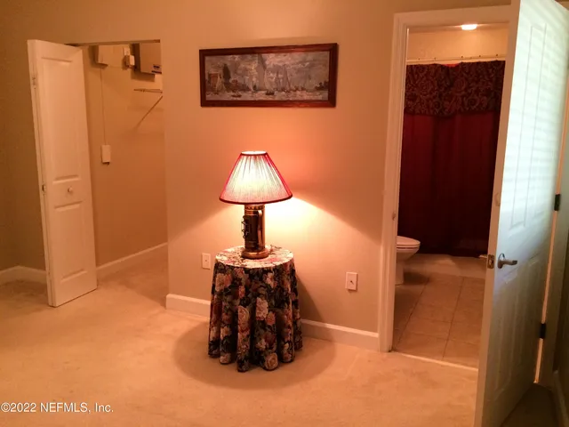 a bathroom with a sink a toilet a mirror and shower curtain