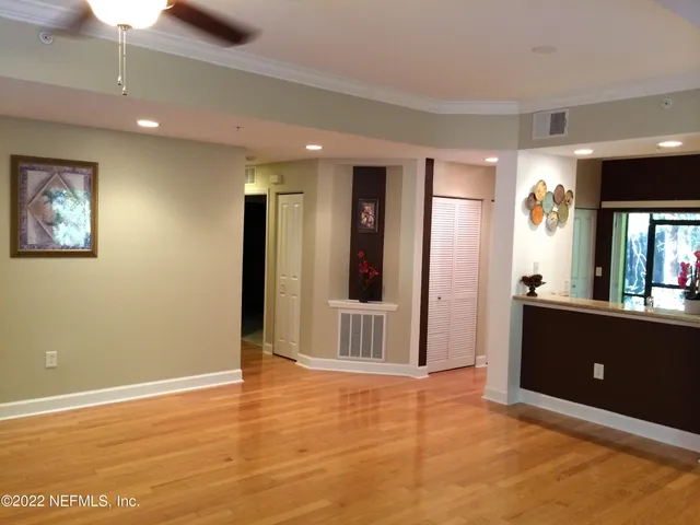 a view of a big room with wooden floor and windows