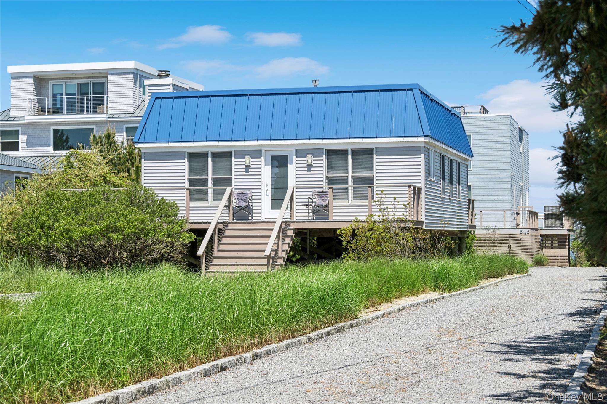 View of front of property featuring metal roof, a standing seam roof, and stairway