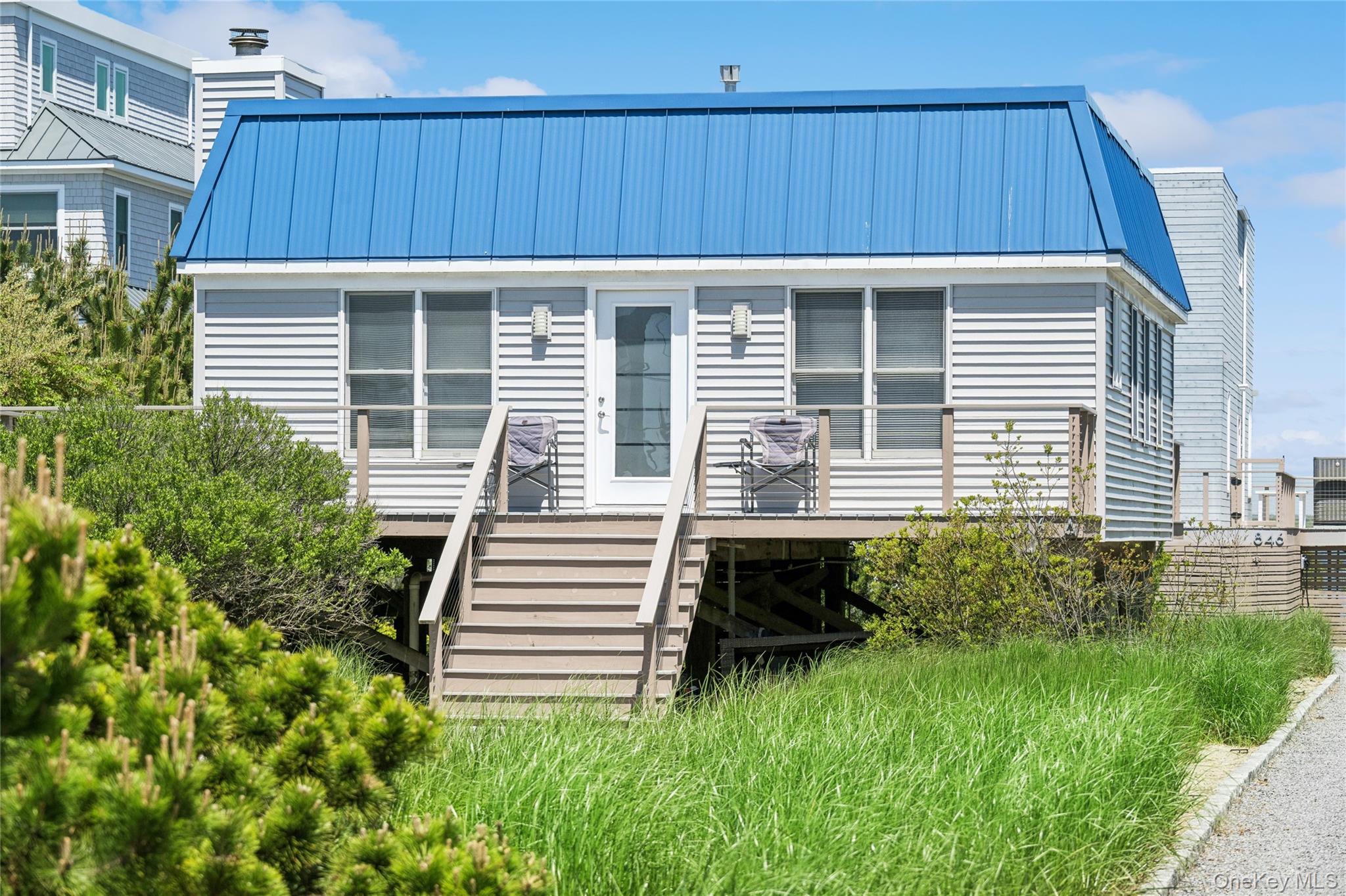 846 Dune Road Westhampton Beach, NY 11978 - Photo 2 of 34 View of front of house with stairs, metal roof, and a deck