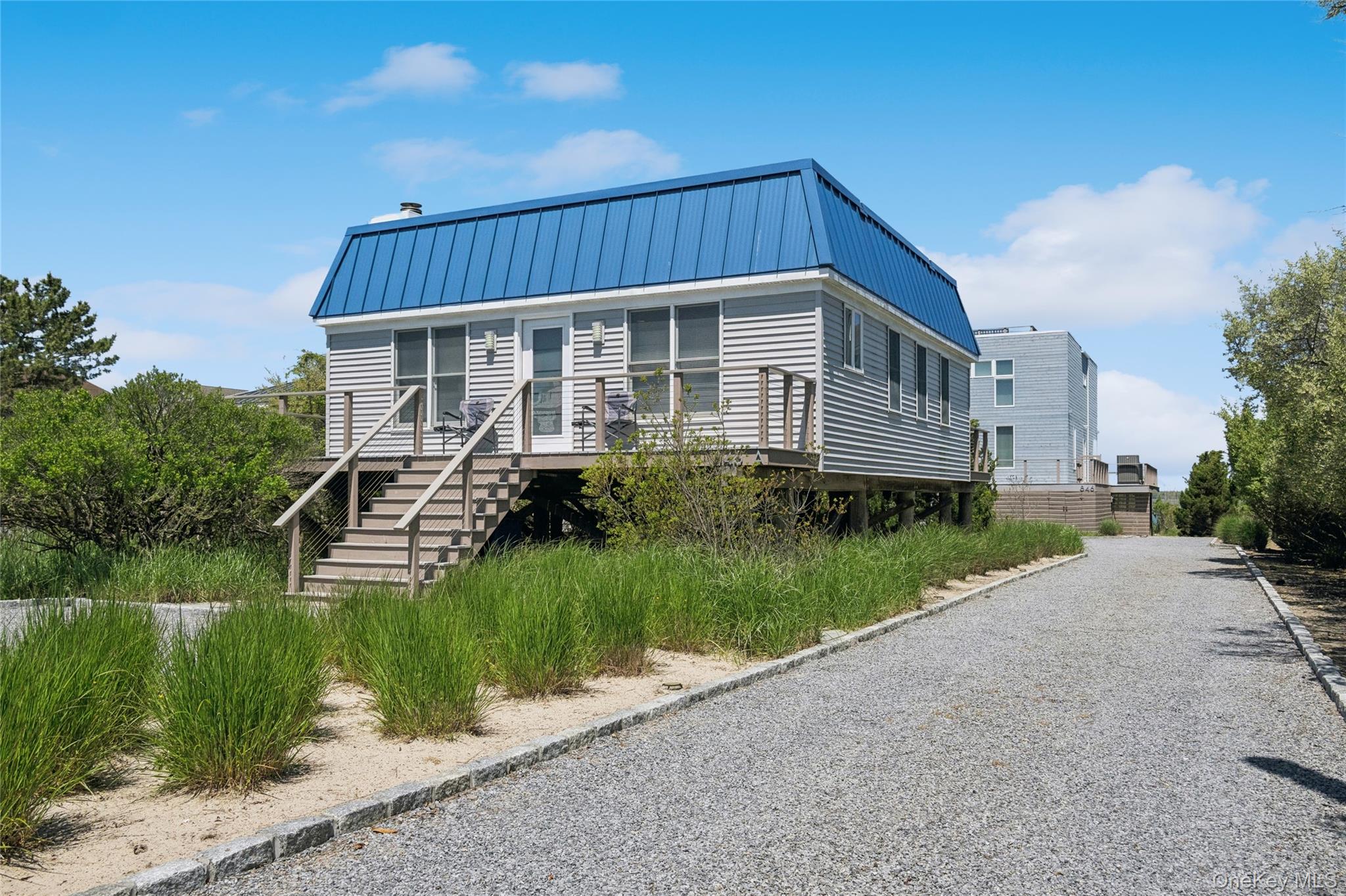 846 Dune Road Westhampton Beach, NY 11978 - Photo 3 of 34 View of front of house featuring a standing seam roof, driveway, stairway, and metal roof