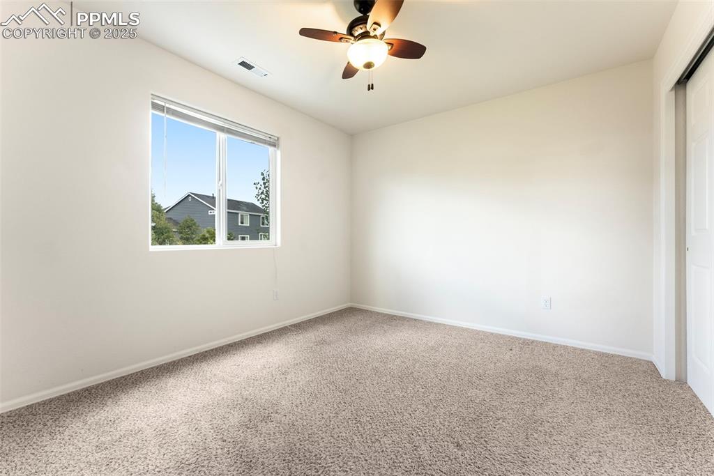 12210 Crystal Downs Road Peyton, CO 80831 - Photo 21 of 50 Carpeted empty room with ceiling fan and baseboards