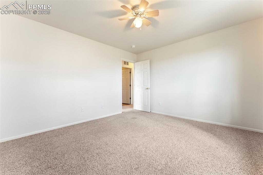 12210 Crystal Downs Road Peyton, CO 80831 - Photo 25 of 50 Carpeted spare room with baseboards and ceiling fan