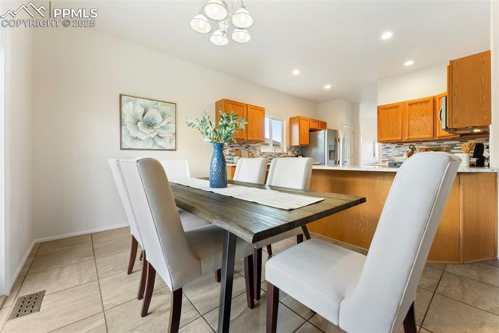 12210 Crystal Downs Road Peyton, CO 80831 - Photo 7 of 50 Dining space with a chandelier, recessed lighting, and light tile patterned floors