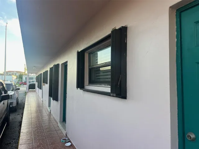 a hallway with wooden floor and a large window