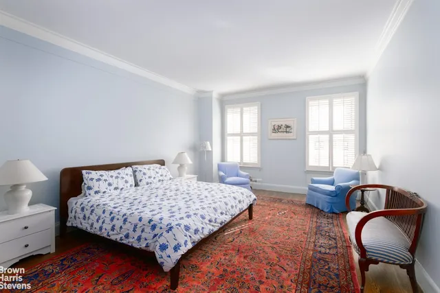 a bedroom with a bed chair and window