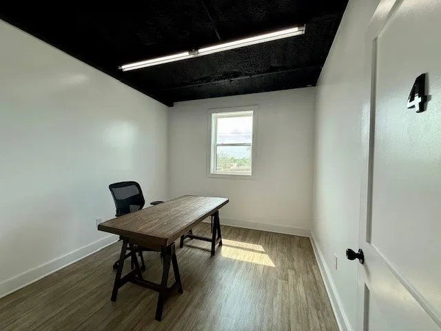 a view of a workspace with furniture and wooden floor