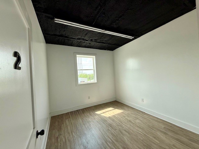 617 Main Street Lexington, TX 78947 - Photo 17 of 25 Empty room featuring luxury vinyl plank floors and baseboards