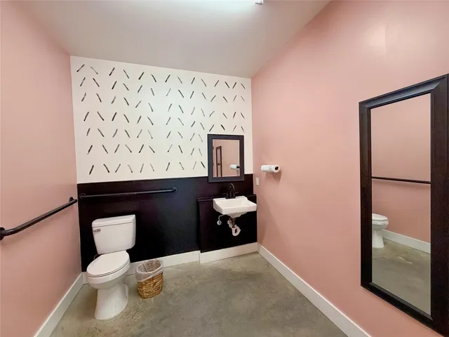 a bathroom with a toilet a sink and mirror