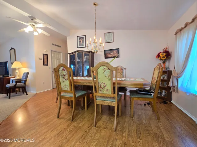 a dining room with furniture a chandelier and wooden floor