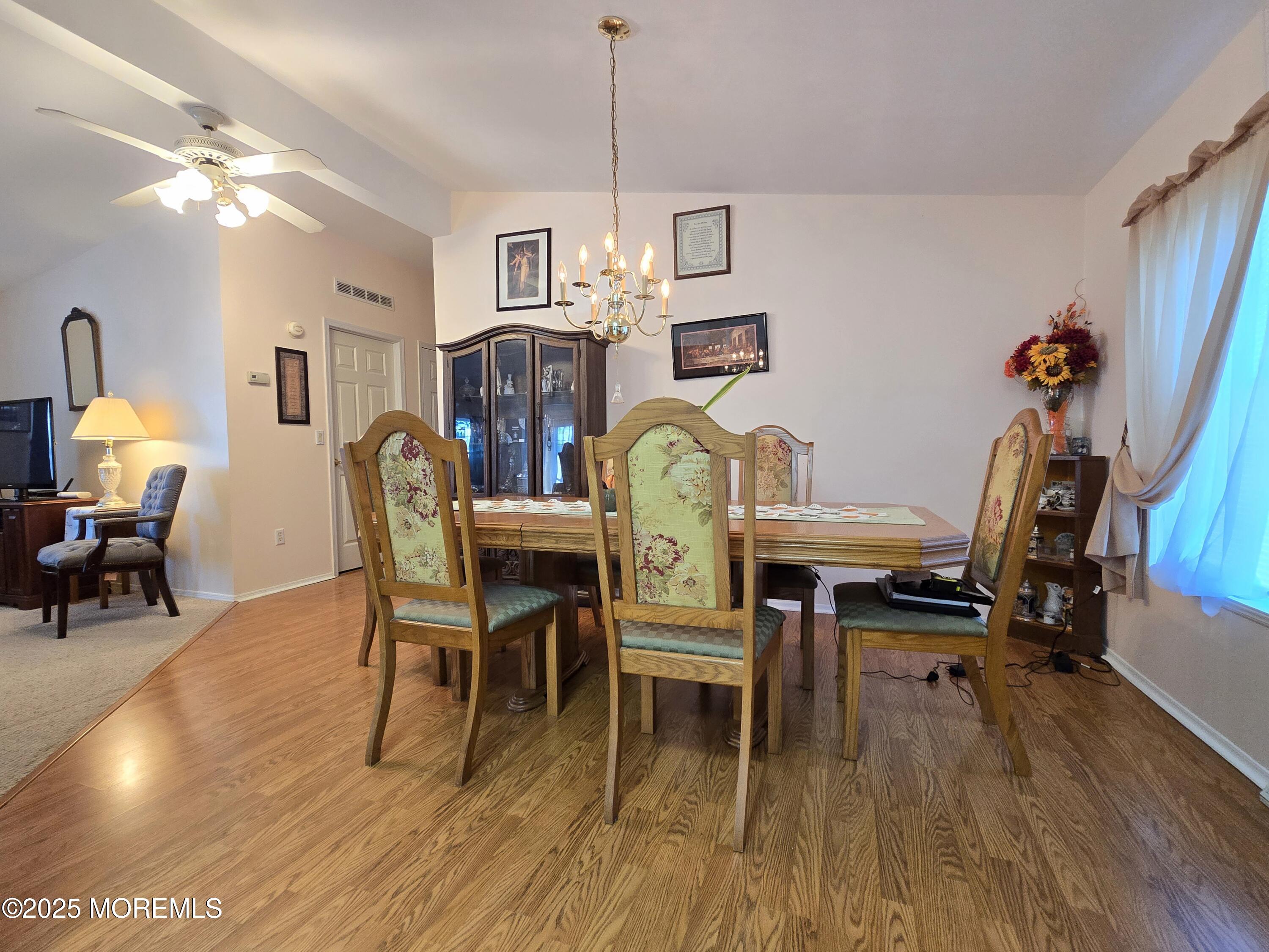 98 Woody Road Freehold, NJ 07728 - Photo 11 of 37 a dining room with furniture a chandelier and wooden floor