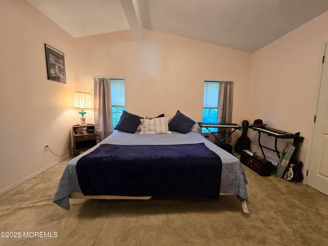 a bedroom with a bed a lamp and paintings on the wall