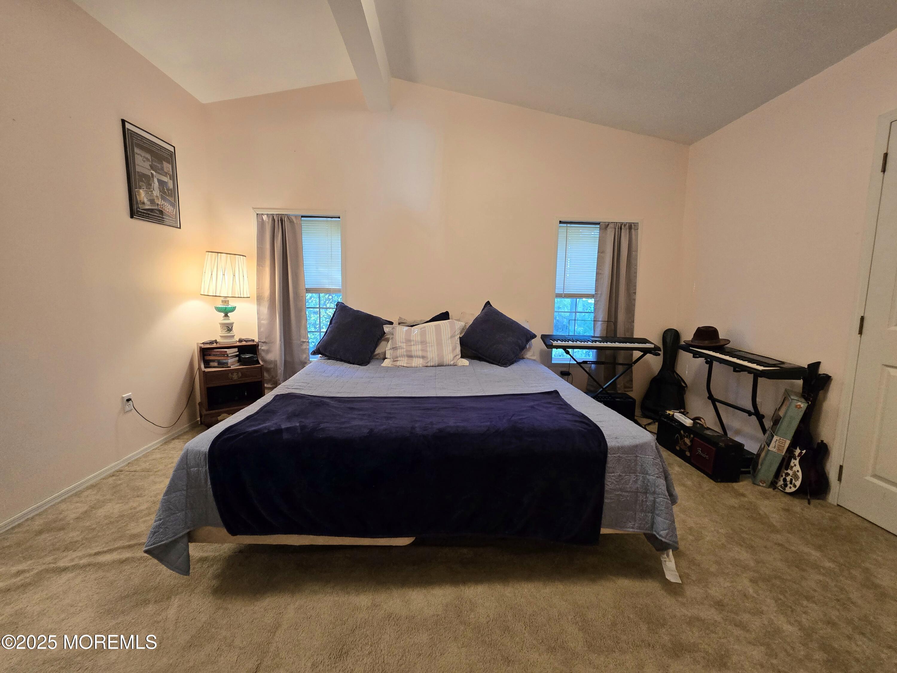 98 Woody Road Freehold, NJ 07728 - Photo 17 of 37 a bedroom with a bed a lamp and paintings on the wall