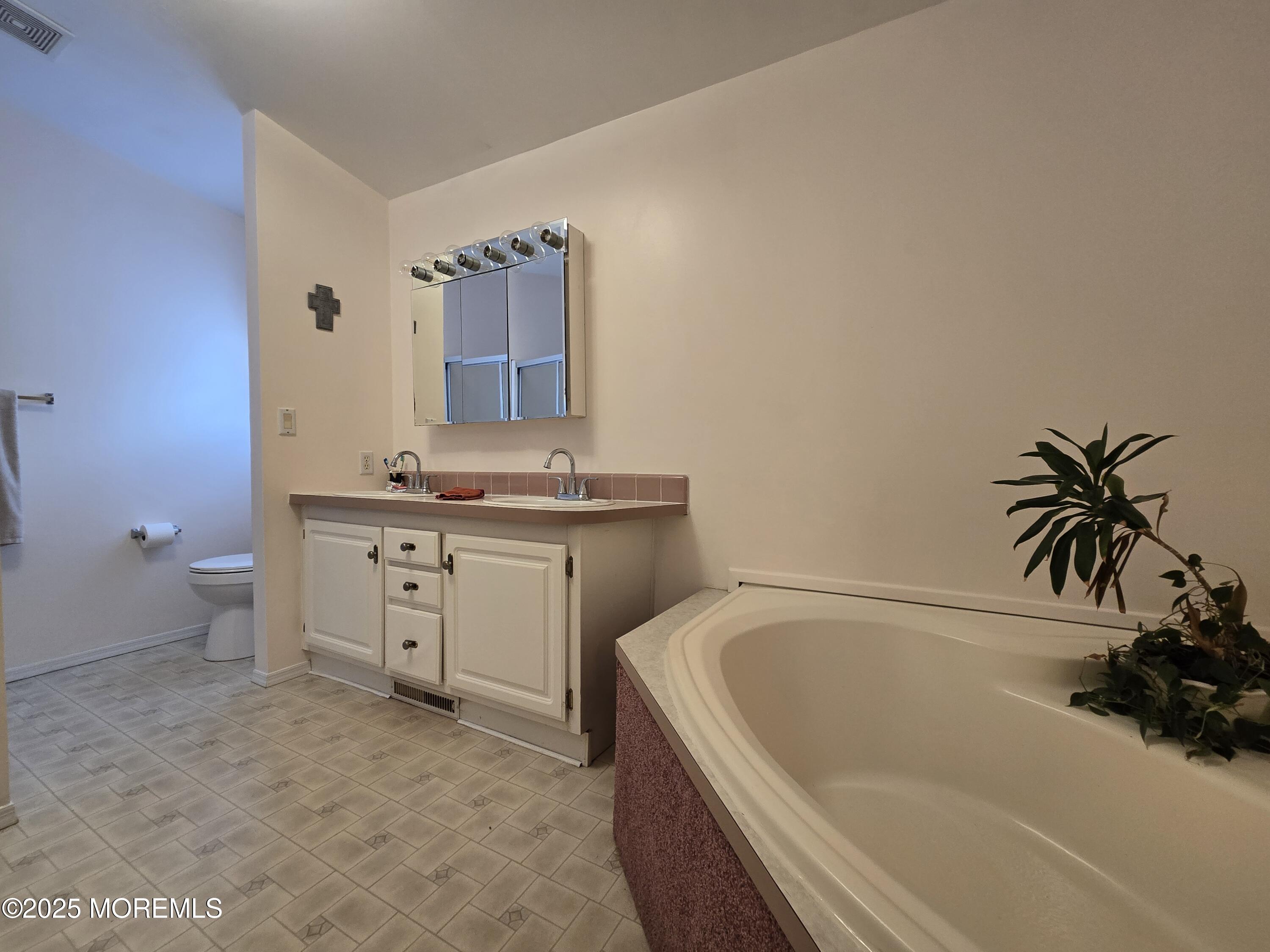 98 Woody Road Freehold, NJ 07728 - Photo 19 of 37 a bathroom with a tub sink and mirror