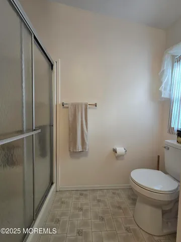 a bathroom with a toilet and a shower