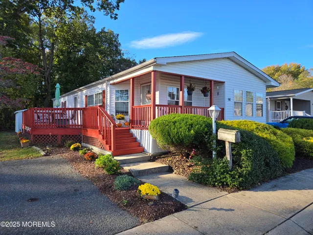 a front view of a house with yard and a garden