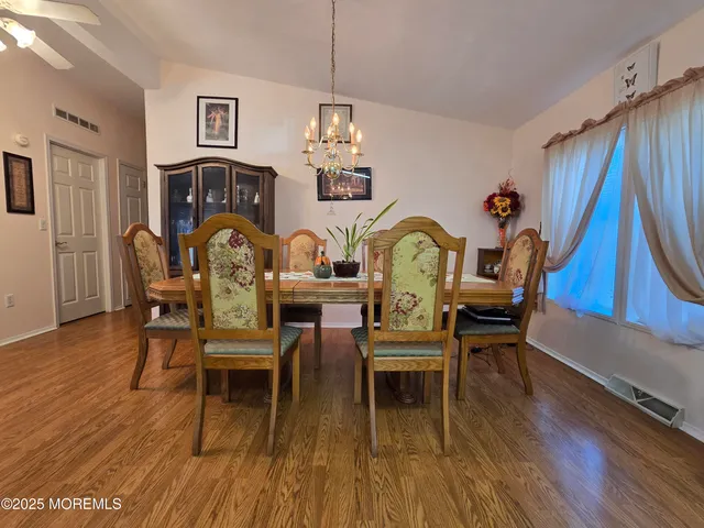 a dining room with furniture a chandelier and wooden floor