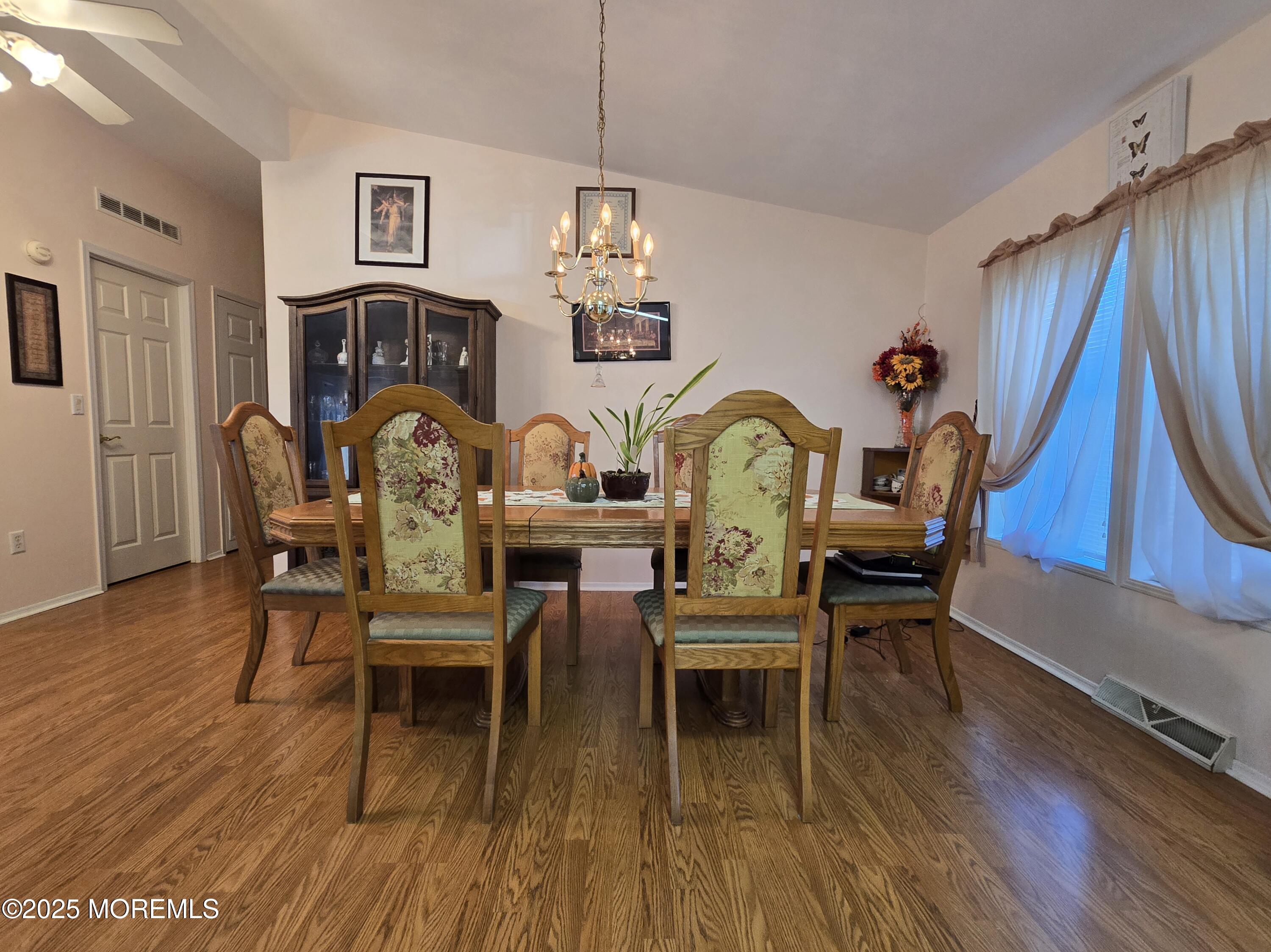 98 Woody Road Freehold, NJ 07728 - Photo 9 of 37 a dining room with furniture a chandelier and wooden floor