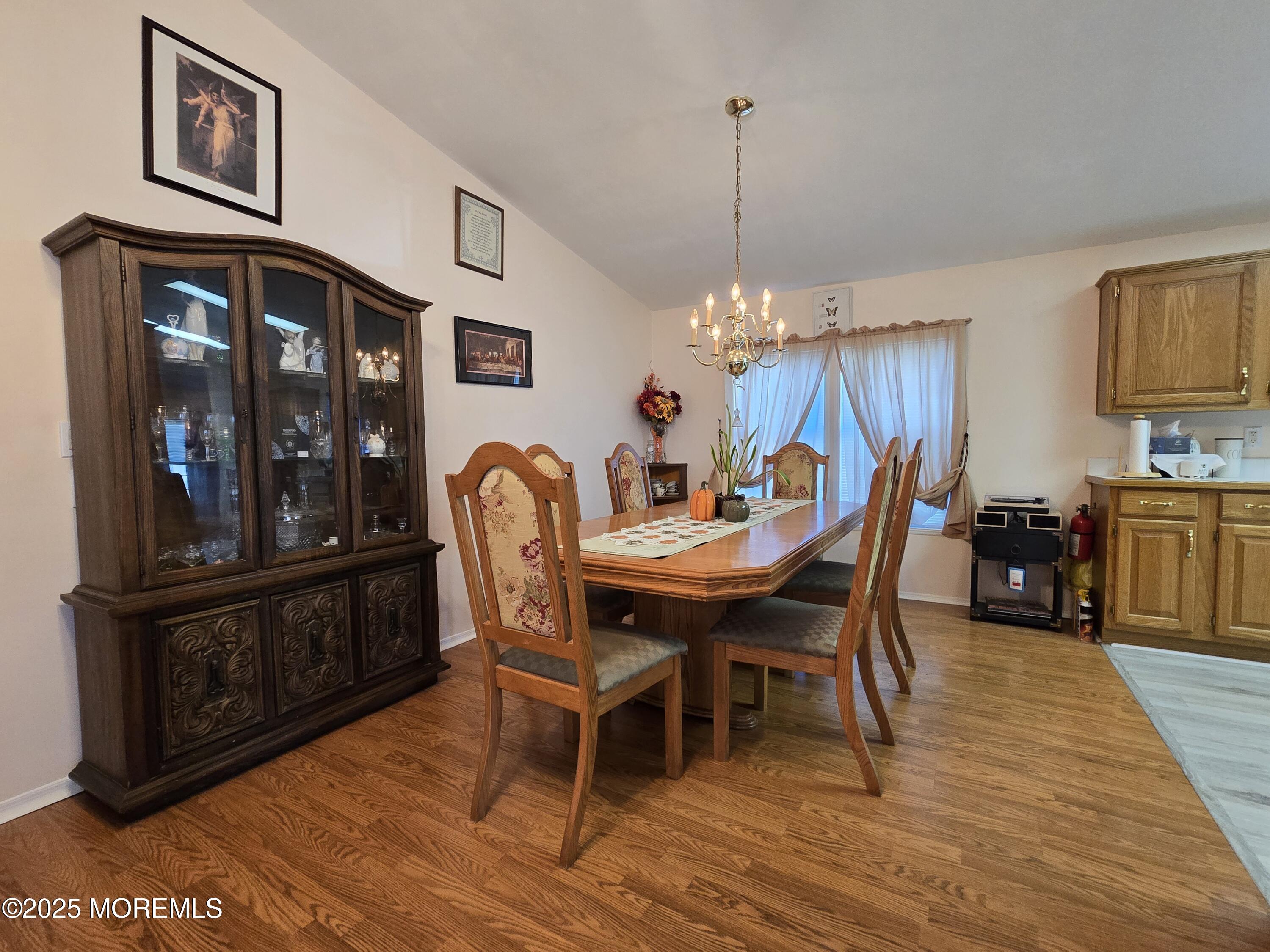 98 Woody Road Freehold, NJ 07728 - Photo 10 of 37 a dining room with furniture a chandelier and wooden floor