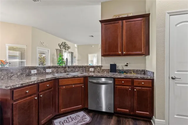a kitchen with stainless steel appliances granite countertop wooden cabinets and a sink