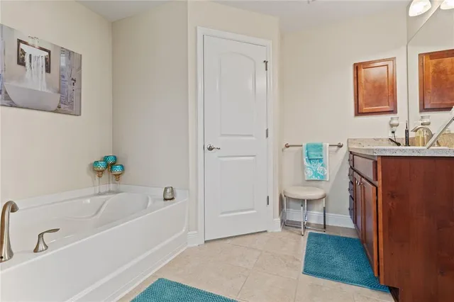 a white bath tub sitting next to a white sink and a mirror