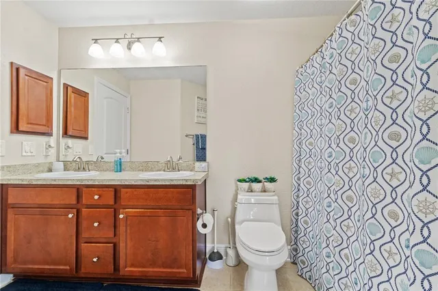a bathroom with a granite countertop toilet sink and mirror