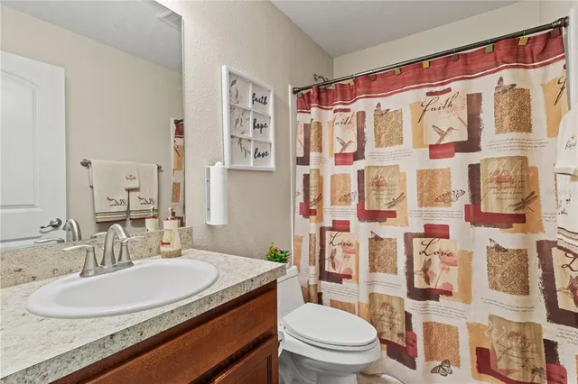 a bathroom with a granite countertop toilet sink and a shower