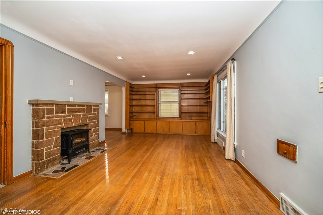 6111 Snow Road Parma, OH 44129 - Photo 5 of 30 Unfurnished living room with light wood-type flooring and a fireplace