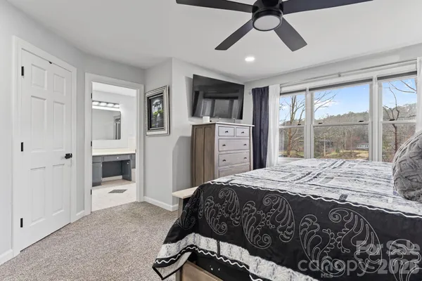 a bedroom with a bed closet and flat screen tv