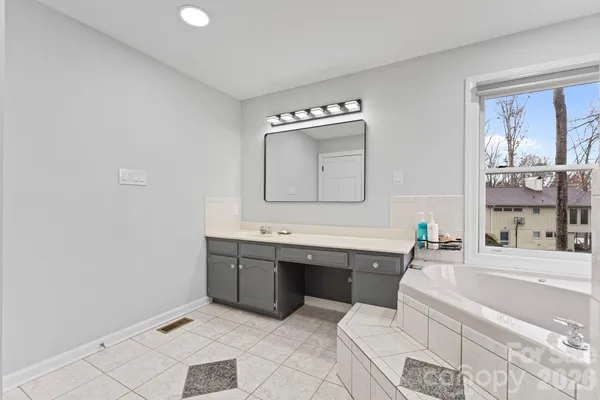 a bathroom with a tub sink and mirror