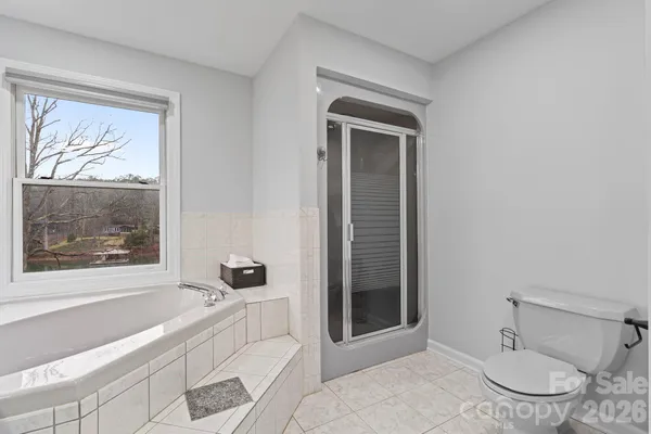 a bathroom with a granite countertop sink a toilet and shower