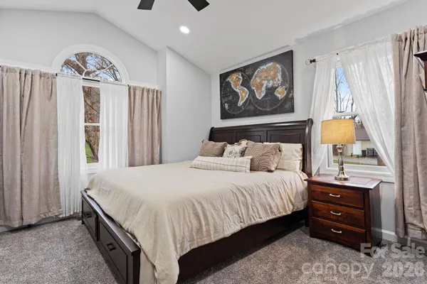 a bedroom with a bed a dresser and painting on the wall