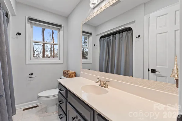 a bathroom with a granite countertop sink toilet a large mirror and shower
