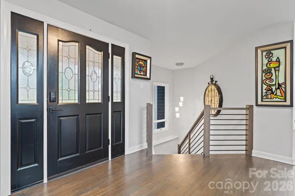 a view of a hallway with wooden floor and staircase