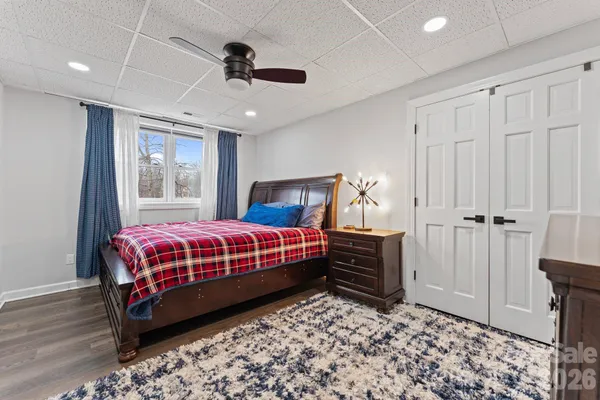 a bedroom with a bed cabinets and wooden floor