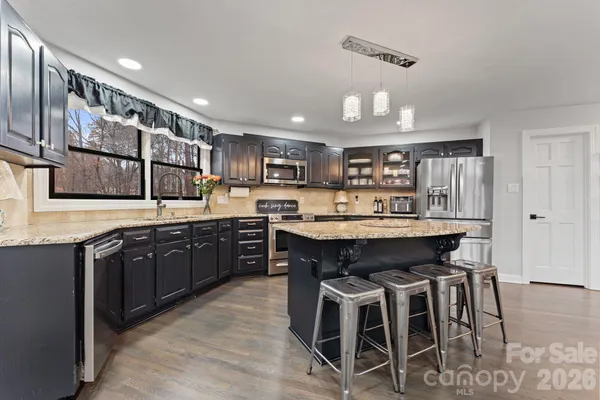a kitchen with a table chairs sink and cabinets
