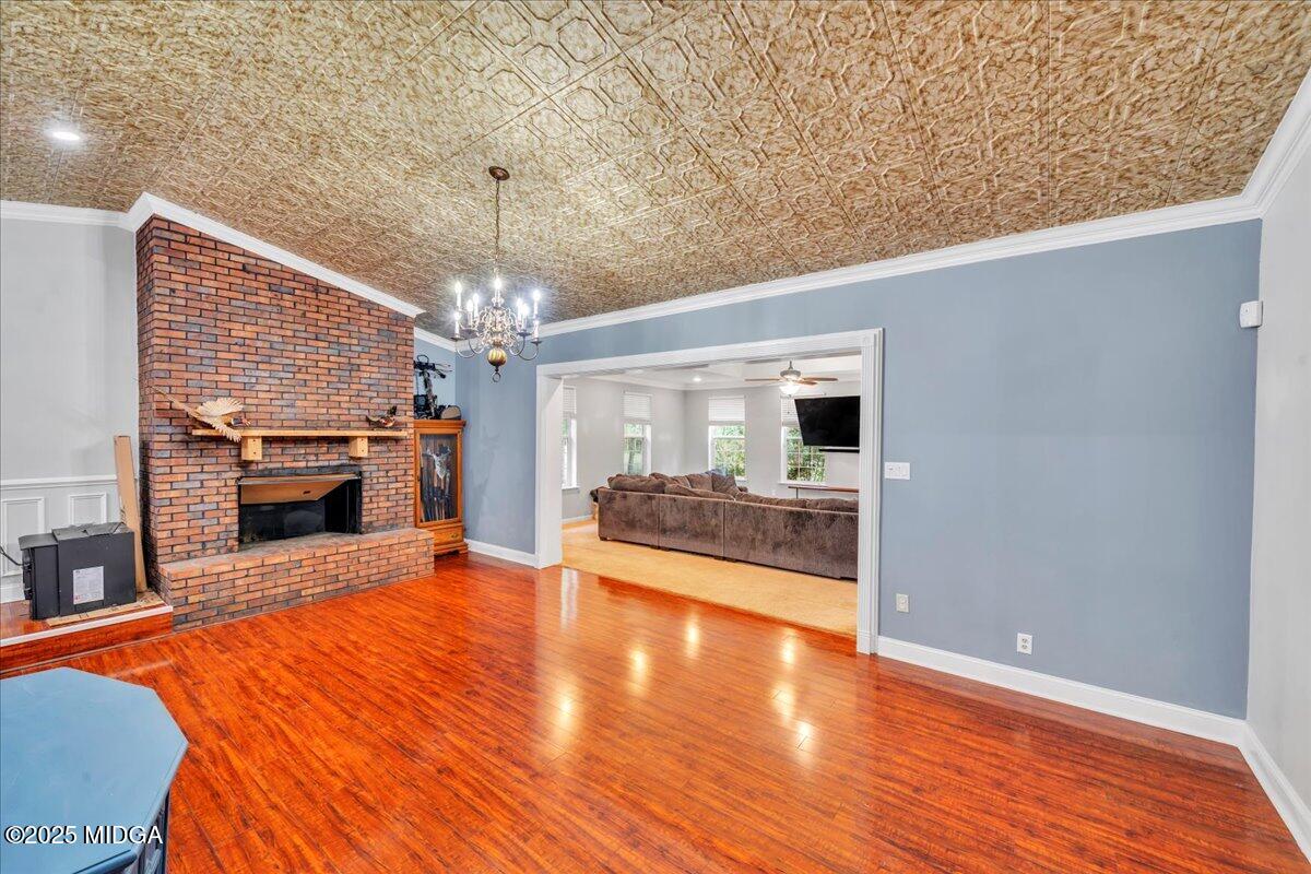 354 Pineview Road Gray, GA 31032 - Photo 16 of 44 a view of a livingroom with a fireplace a chandelier and wooden floor