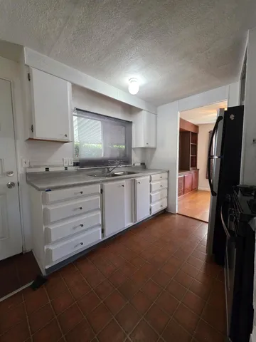a kitchen with stainless steel appliances a sink stove and cabinets